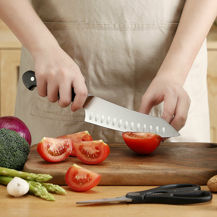 a person cutting tomatoes on a cutting board