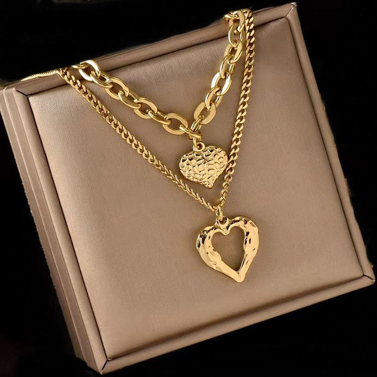 a gold necklace with a heart pendant on it