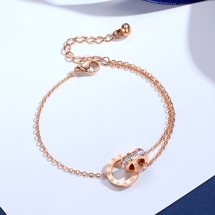 a gold bracelet with a diamond and a chain