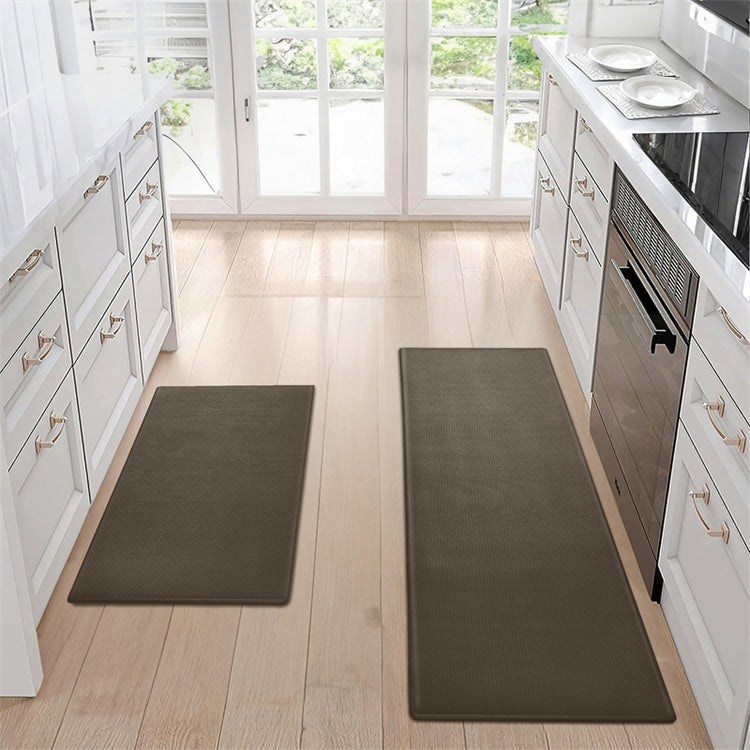 a kitchen with white cabinets and black mats
