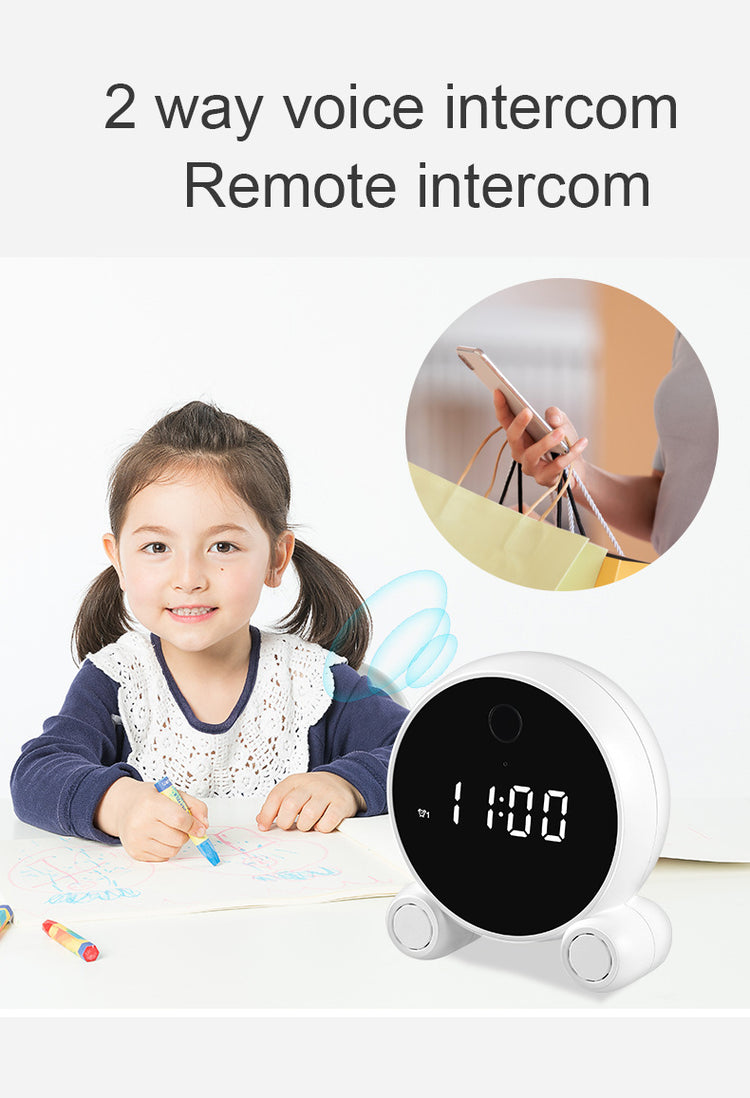 a child sitting at a table with a clock and a picture of a girl