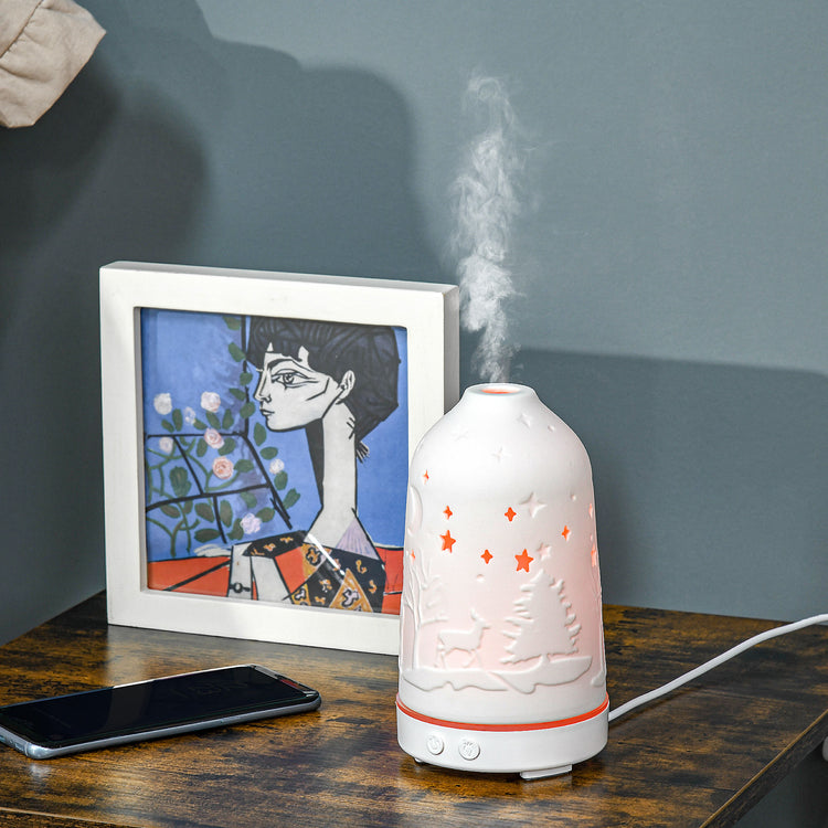 a white humidifier on a table next to a cell phone