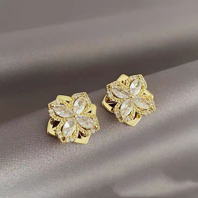 a pair of gold earrings with diamonds