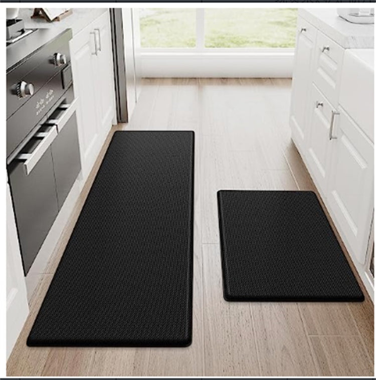 a pair of black rugs in a kitchen