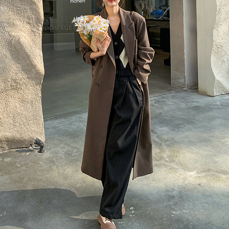 a woman in a long coat holding flowers