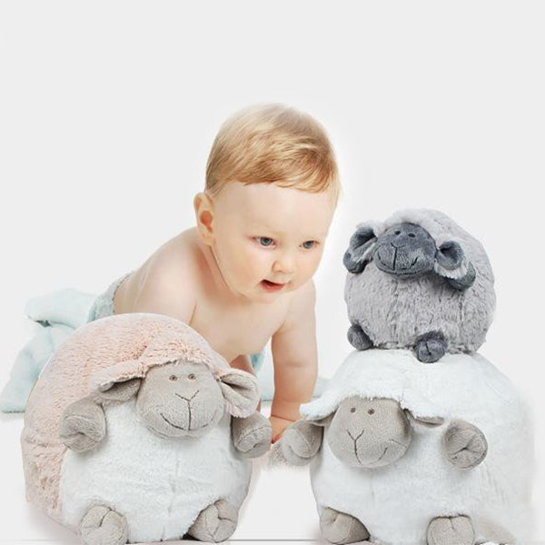 a baby crawling next to stuffed sheep