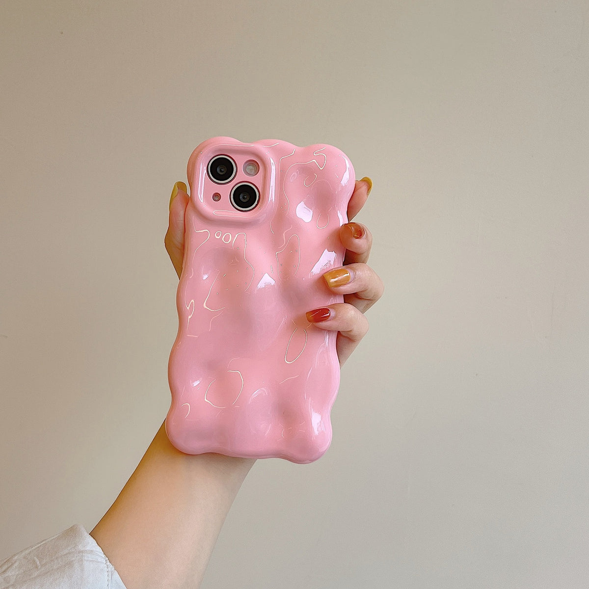 a hand holding a pink phone case