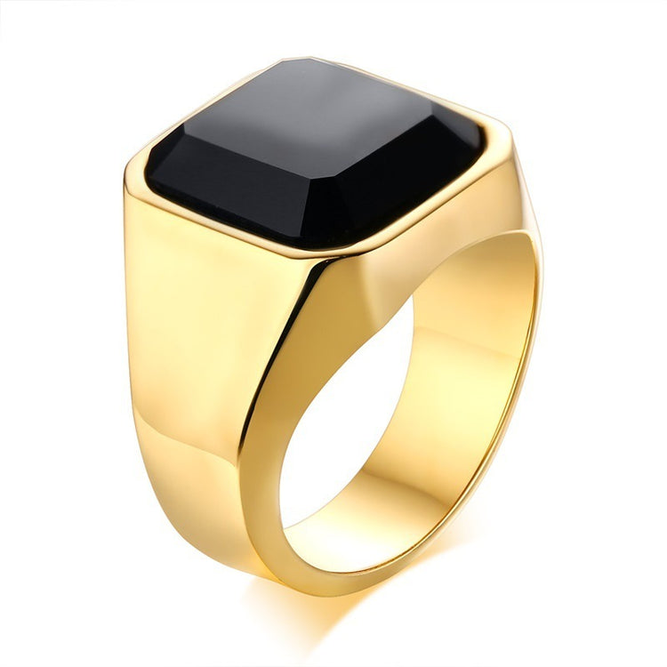 a gold ring with a black stone