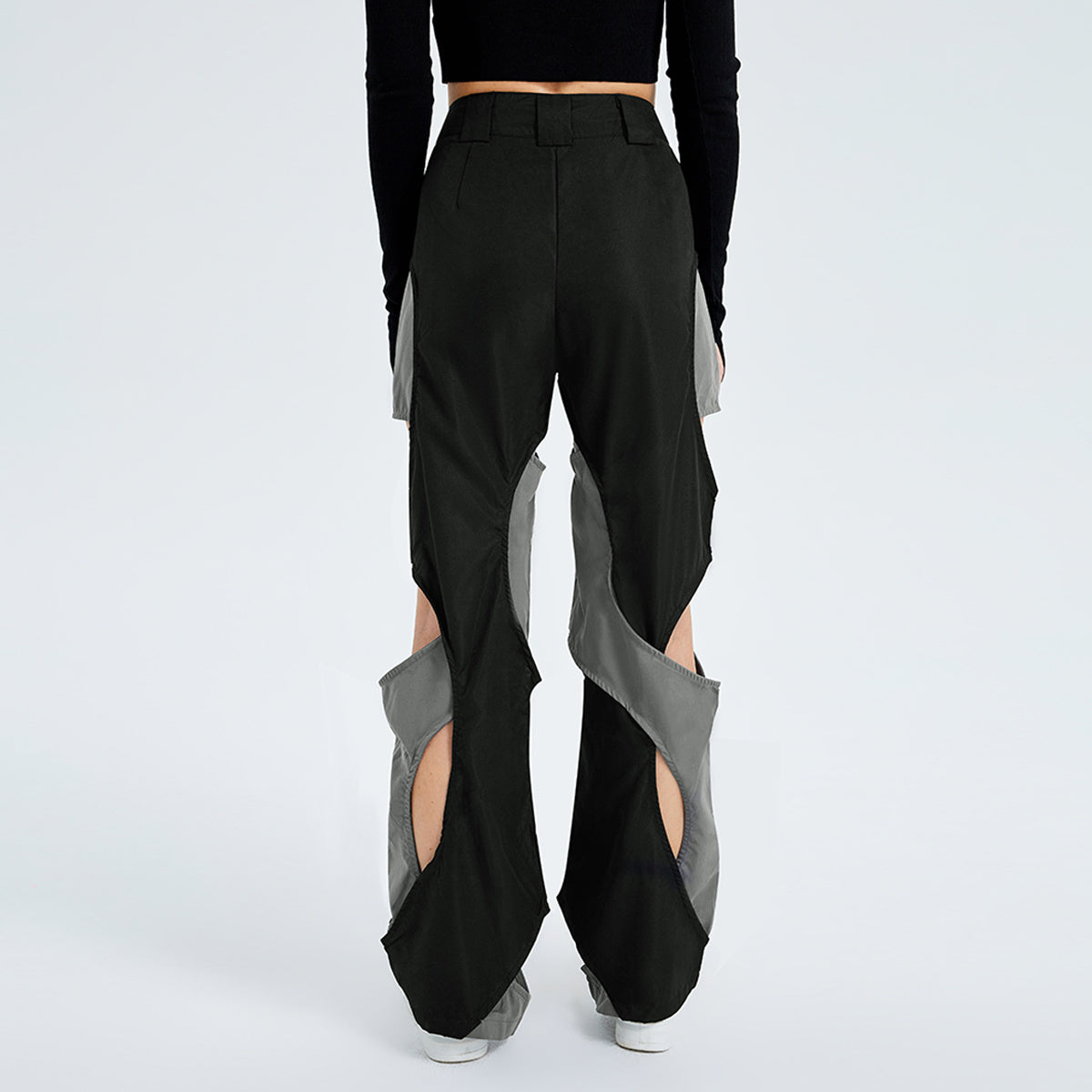 a person wearing black pants with cut out designs