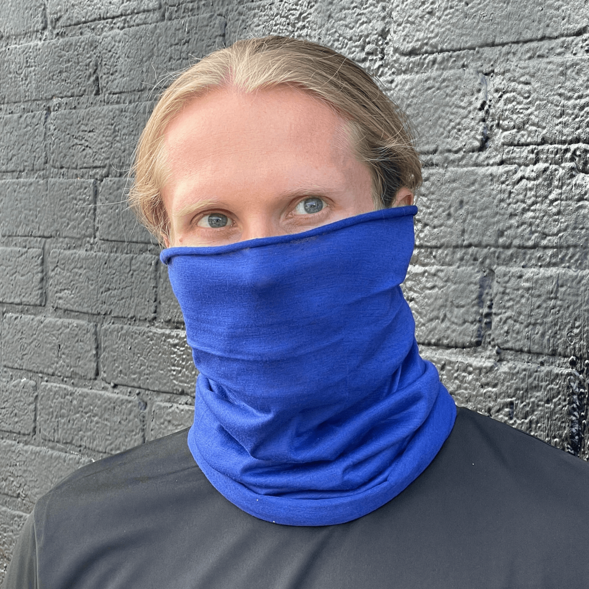 a man wearing a blue scarf over his face
