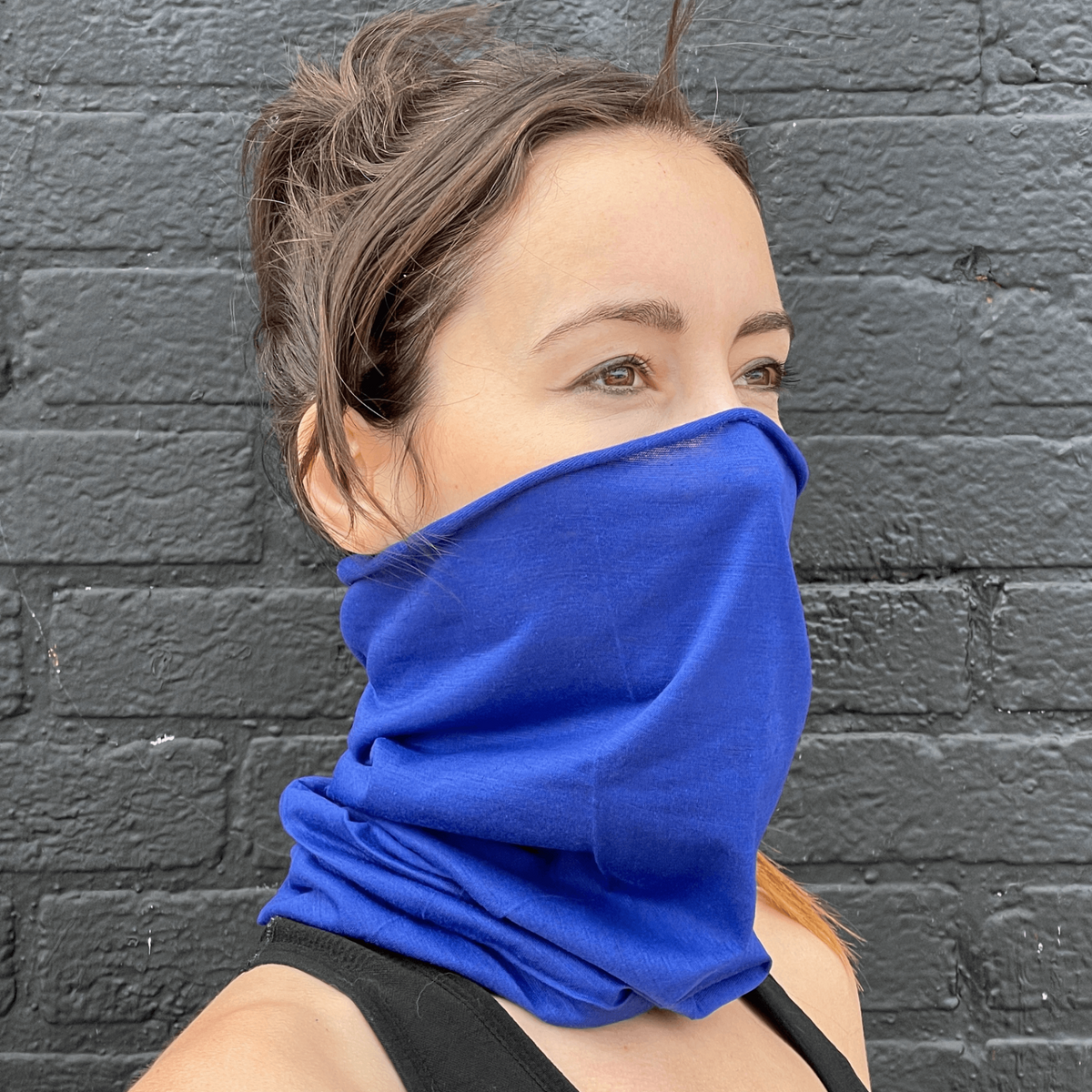 a woman wearing a blue scarf over her face