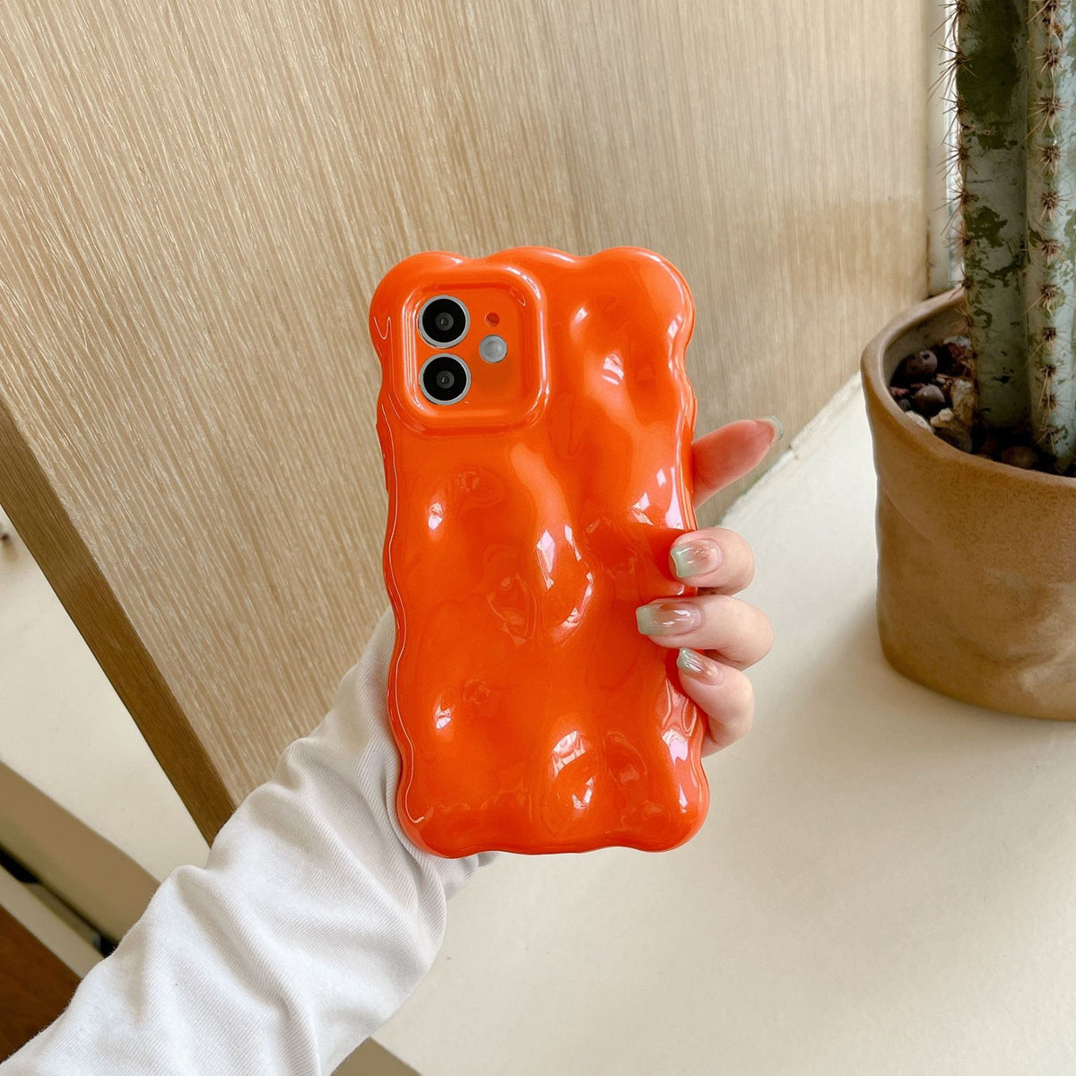 a hand holding an orange phone case