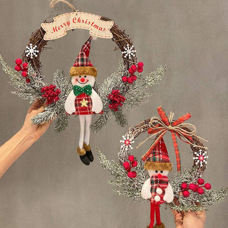 a hand holding a wreath with snowman and a sign