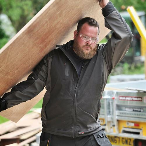 a man carrying a large piece of wood