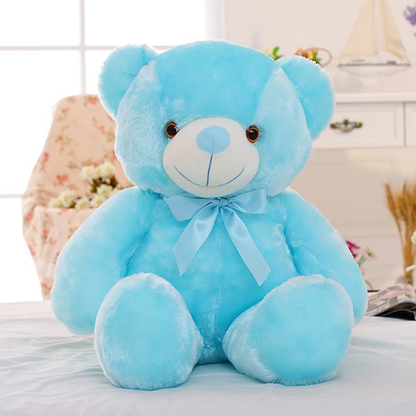 a blue teddy bear on a bed