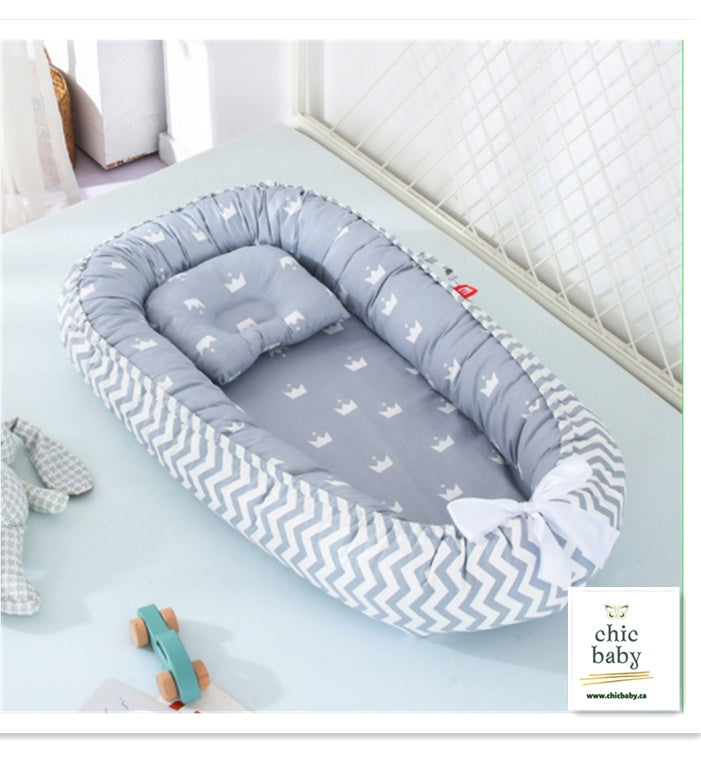 a baby bed with a pillow and a toy