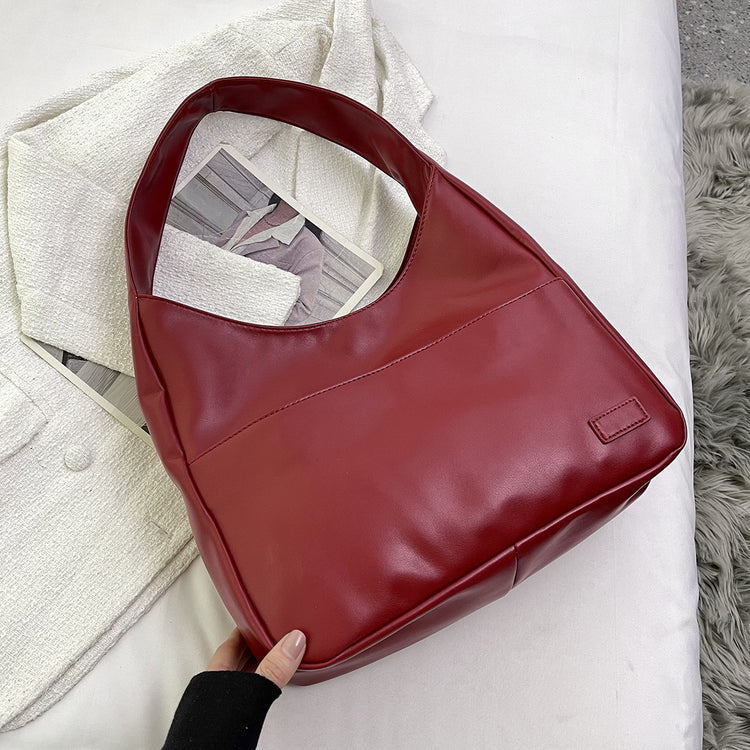 a hand holding a red purse