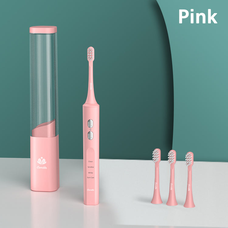 a pink electric toothbrush and a tube