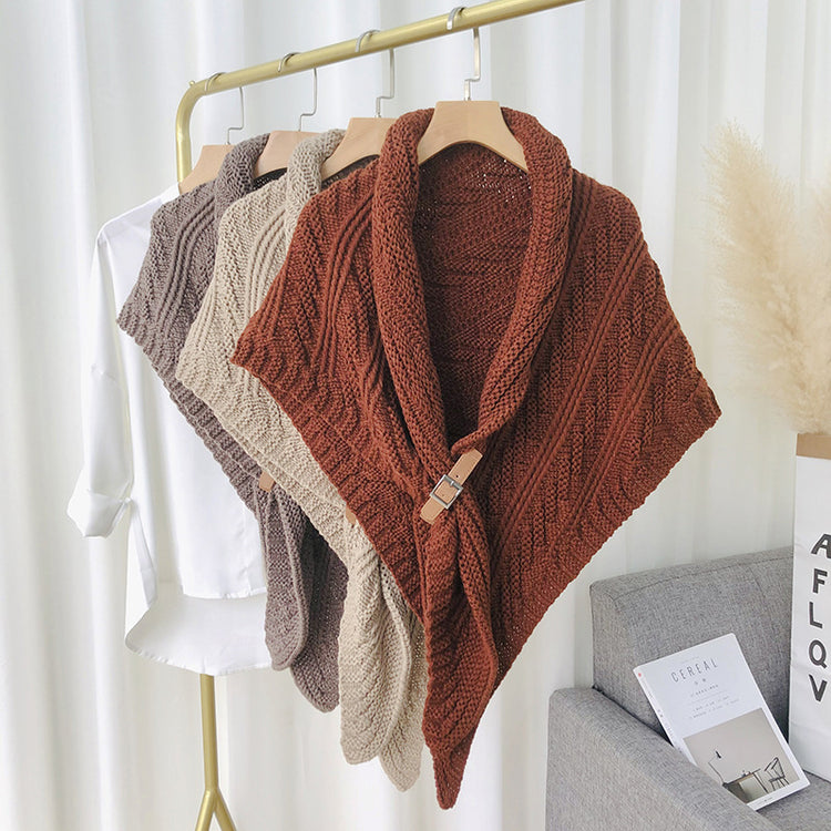 a group of knitted ponchos on a rack