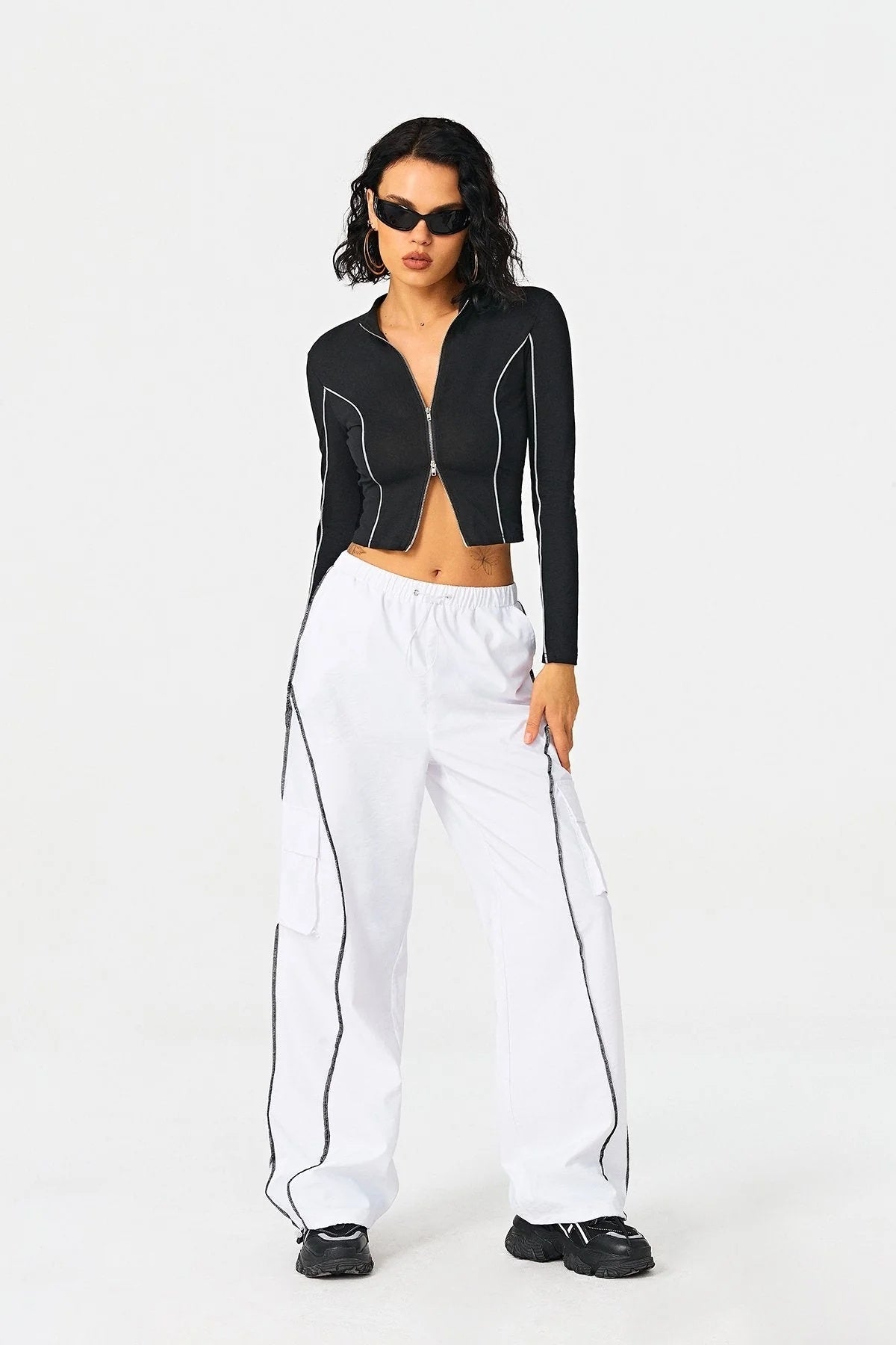 a woman in a black jacket and white pants