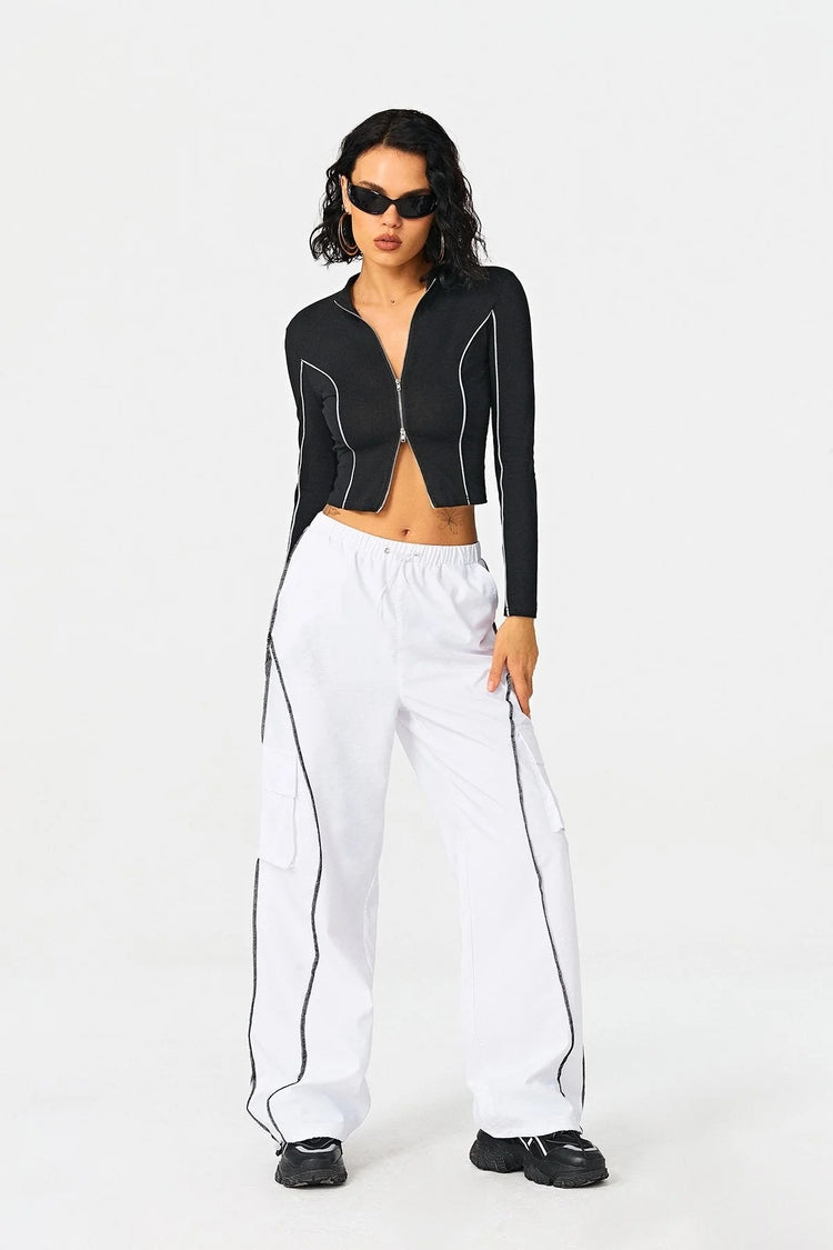 a woman in a black jacket and white pants