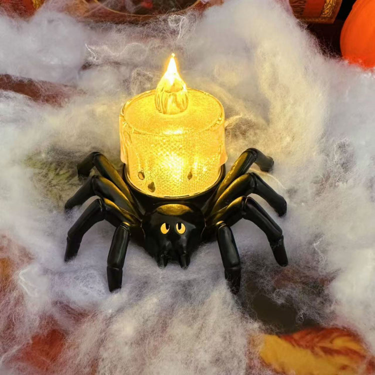 a spider shaped candle holder with a lit candle