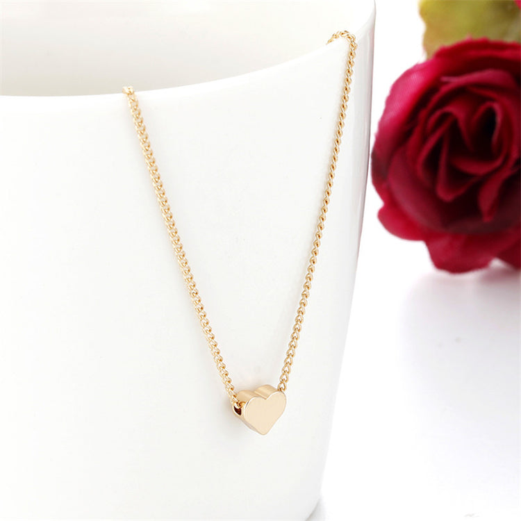 a gold heart necklace on a chain
