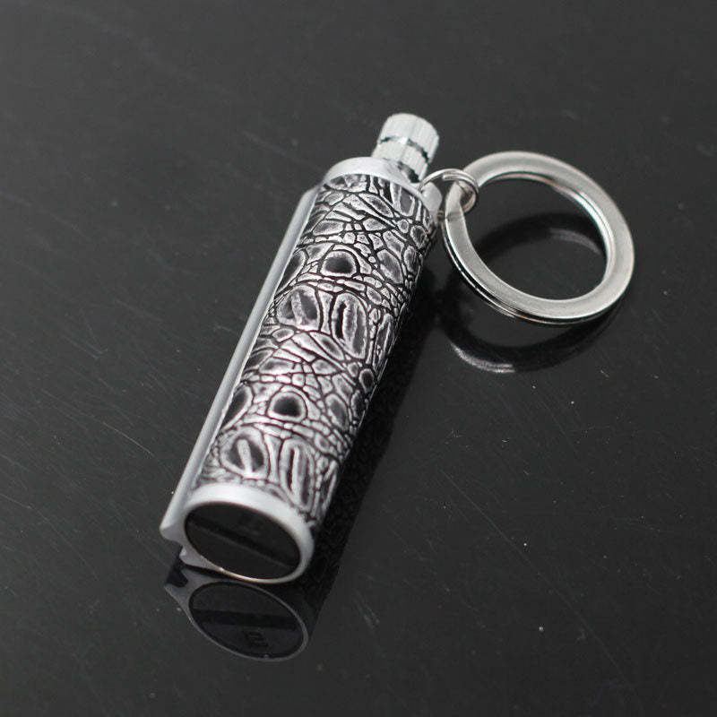 a silver key chain with a crocodile skin design