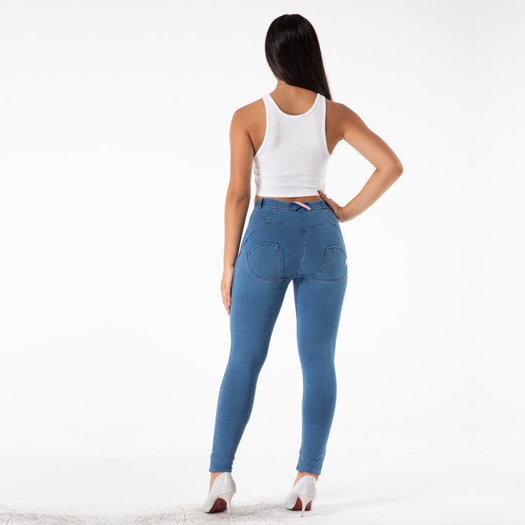 a woman in blue jeans and a white tank top