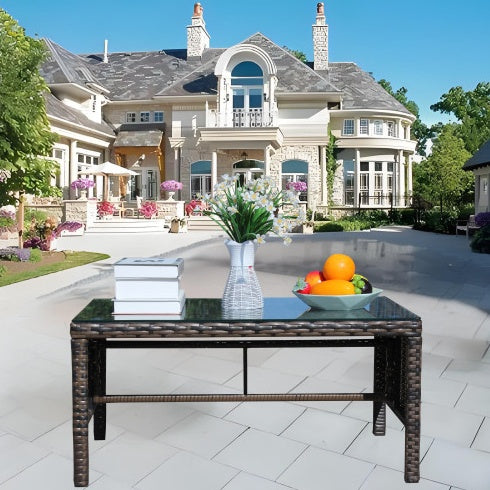 a table with fruit and a vase on it in front of a large house
