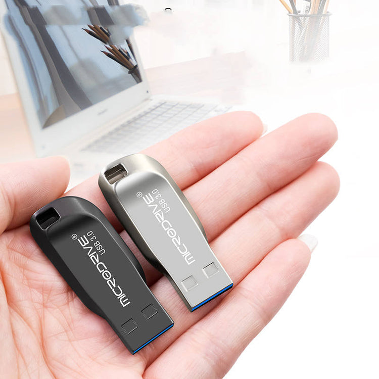 a hand holding two usb drives