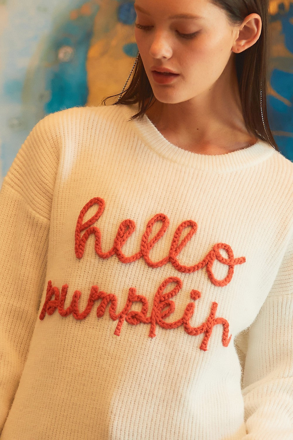 a woman wearing a white sweater with red text on it