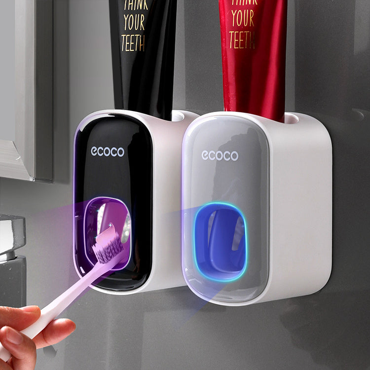 a hand holding a toothbrush and a toothpaste dispenser