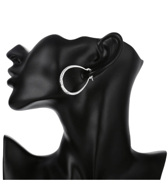 a black mannequin with a silver hoop earring