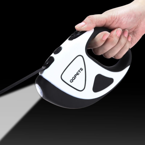 a hand holding a black and white retractable dog leash
