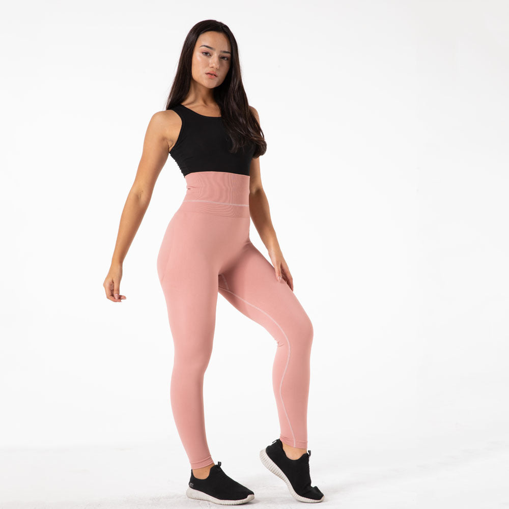 a woman in pink tights and black tank top
