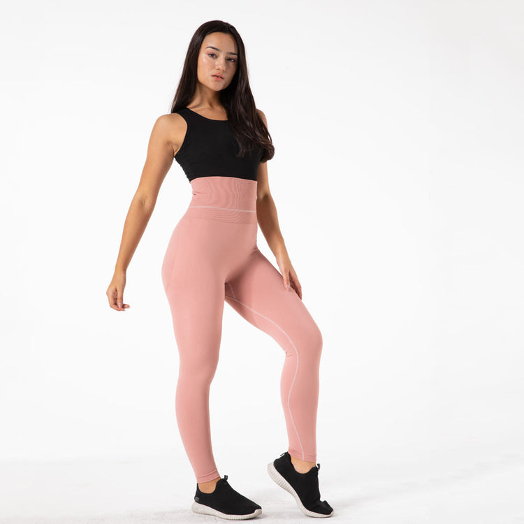 a woman in pink tights and black tank top