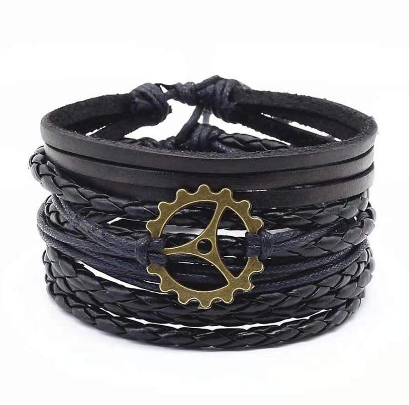a black leather bracelet with a gold gear on it