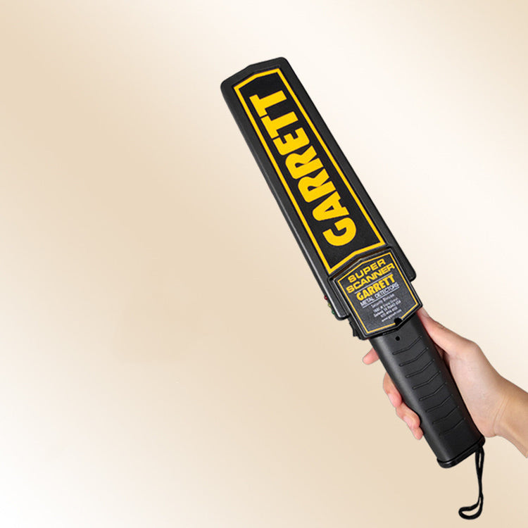 a hand holding a metal detector