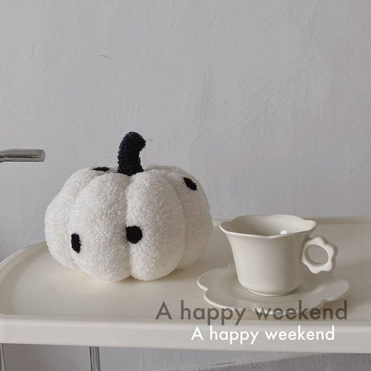 a white pumpkin stuffed toy on a white tray