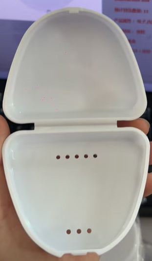 a hand holding a white box