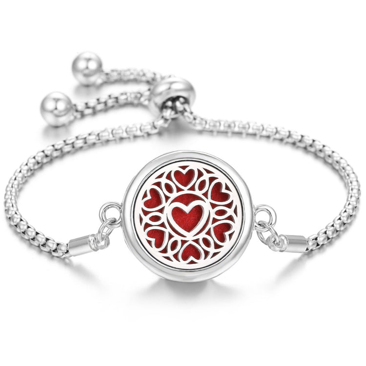 a silver bracelet with a red heart design