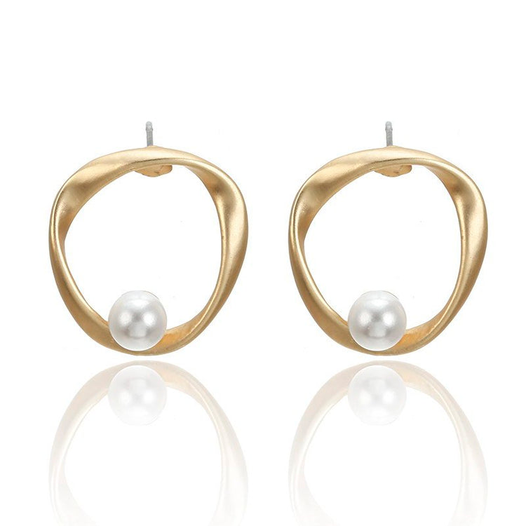 a pair of gold earrings with a pearl in the middle