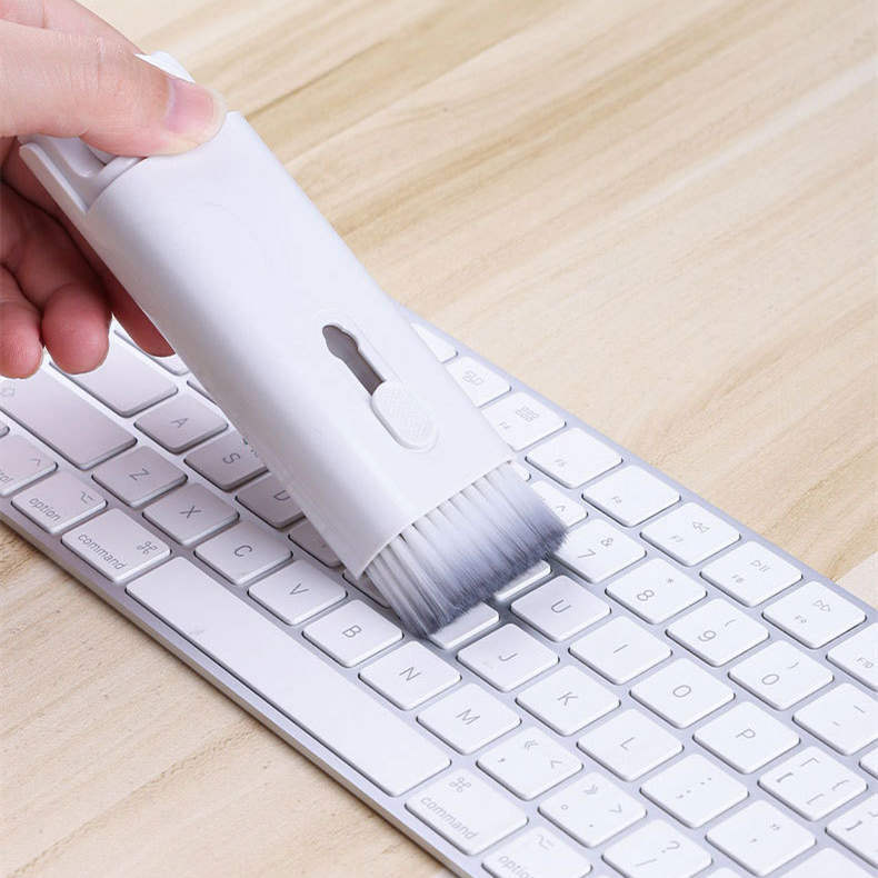 a hand holding a brush on a keyboard