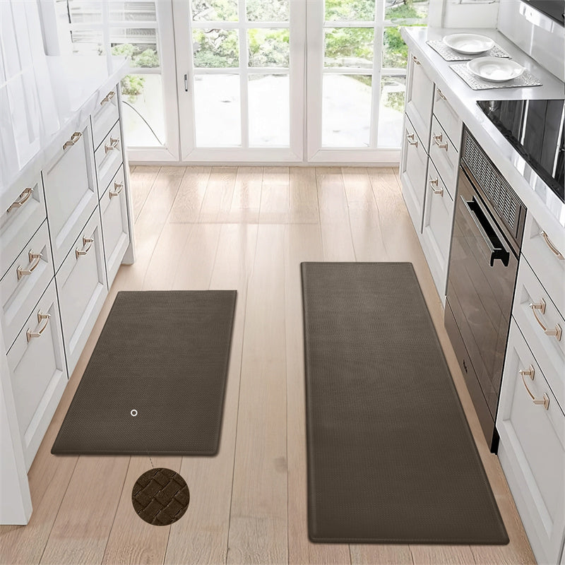 a kitchen with white cabinets and black mats