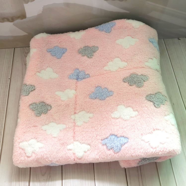 a pink blanket with clouds on it