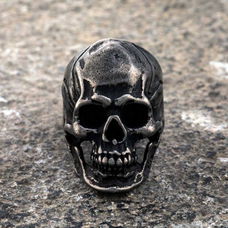 a metal skull on a stone surface