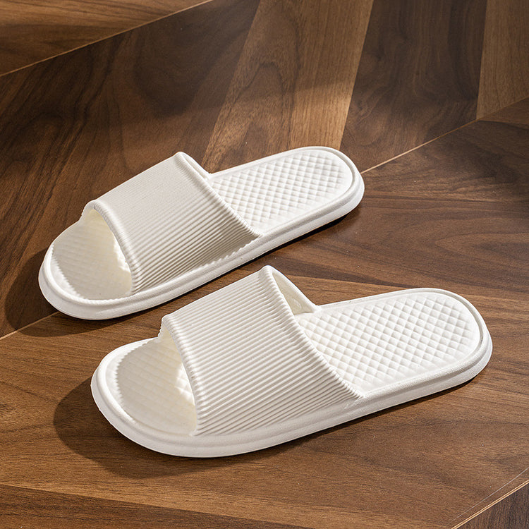 a pair of white slippers on a wood floor