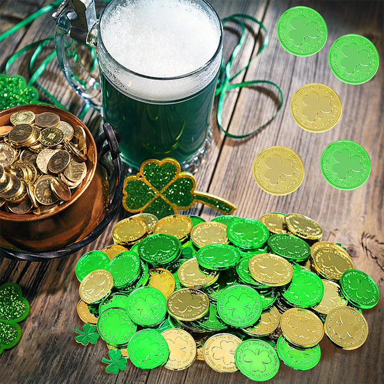 a green and gold coins next to a mug of beer