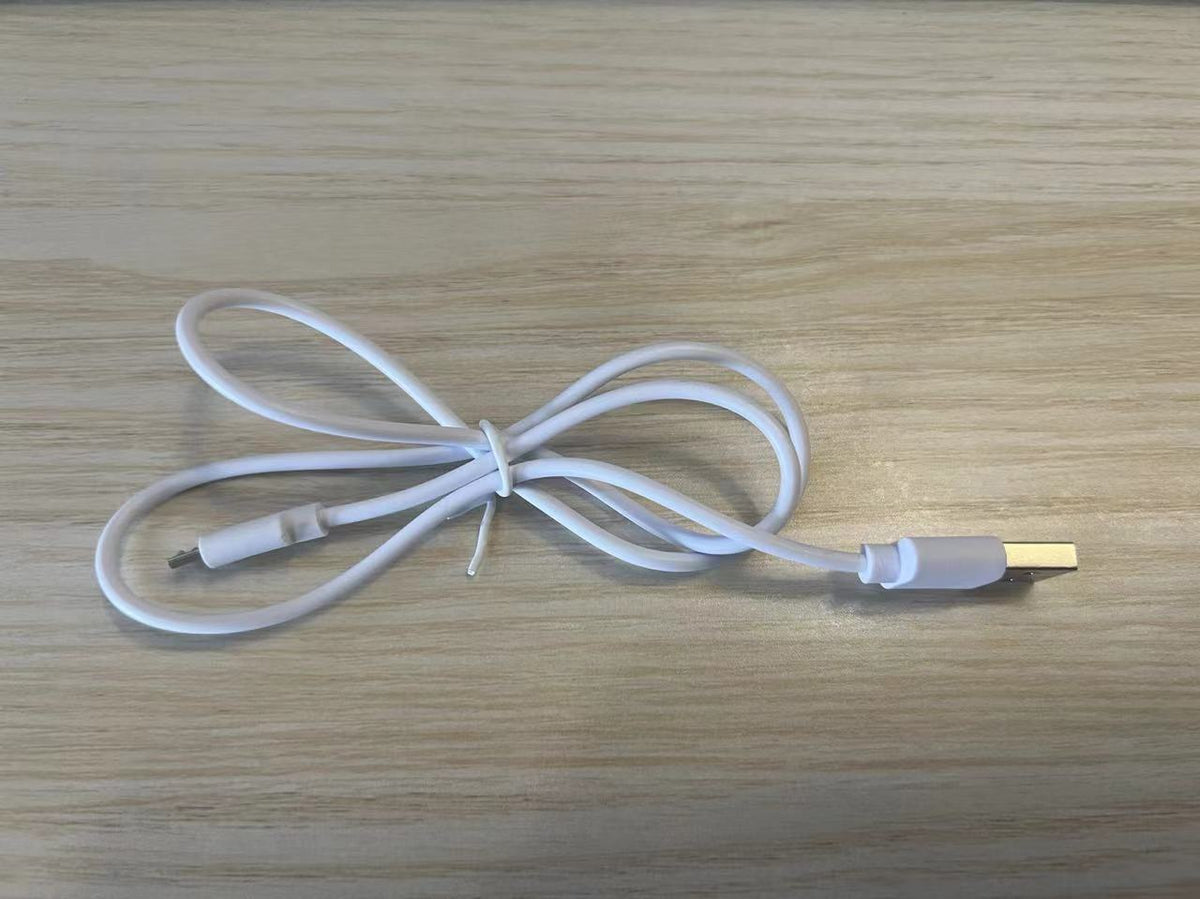 a white cable on a wood surface